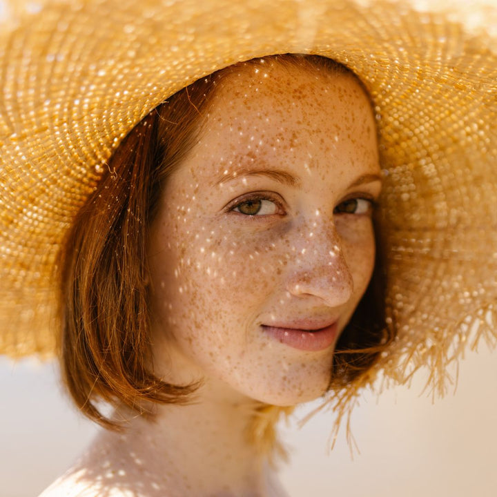 młoda piegowata dziewczyna w kapeluszu, twarz oświetla słońce
